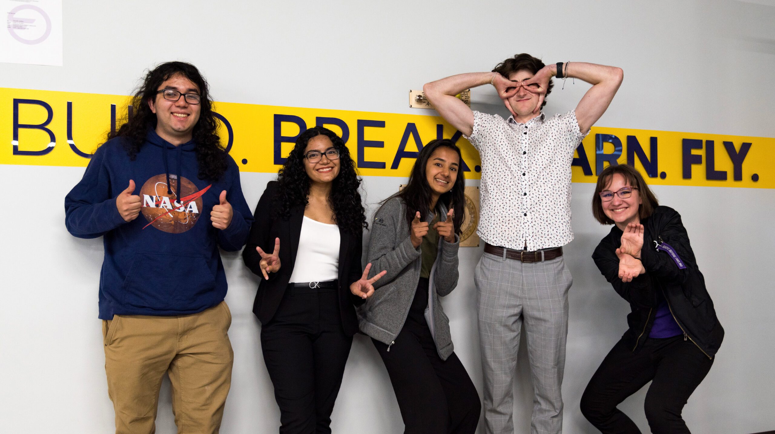 Interns standing in front of our Wall of Fail for Group photo summer 2022