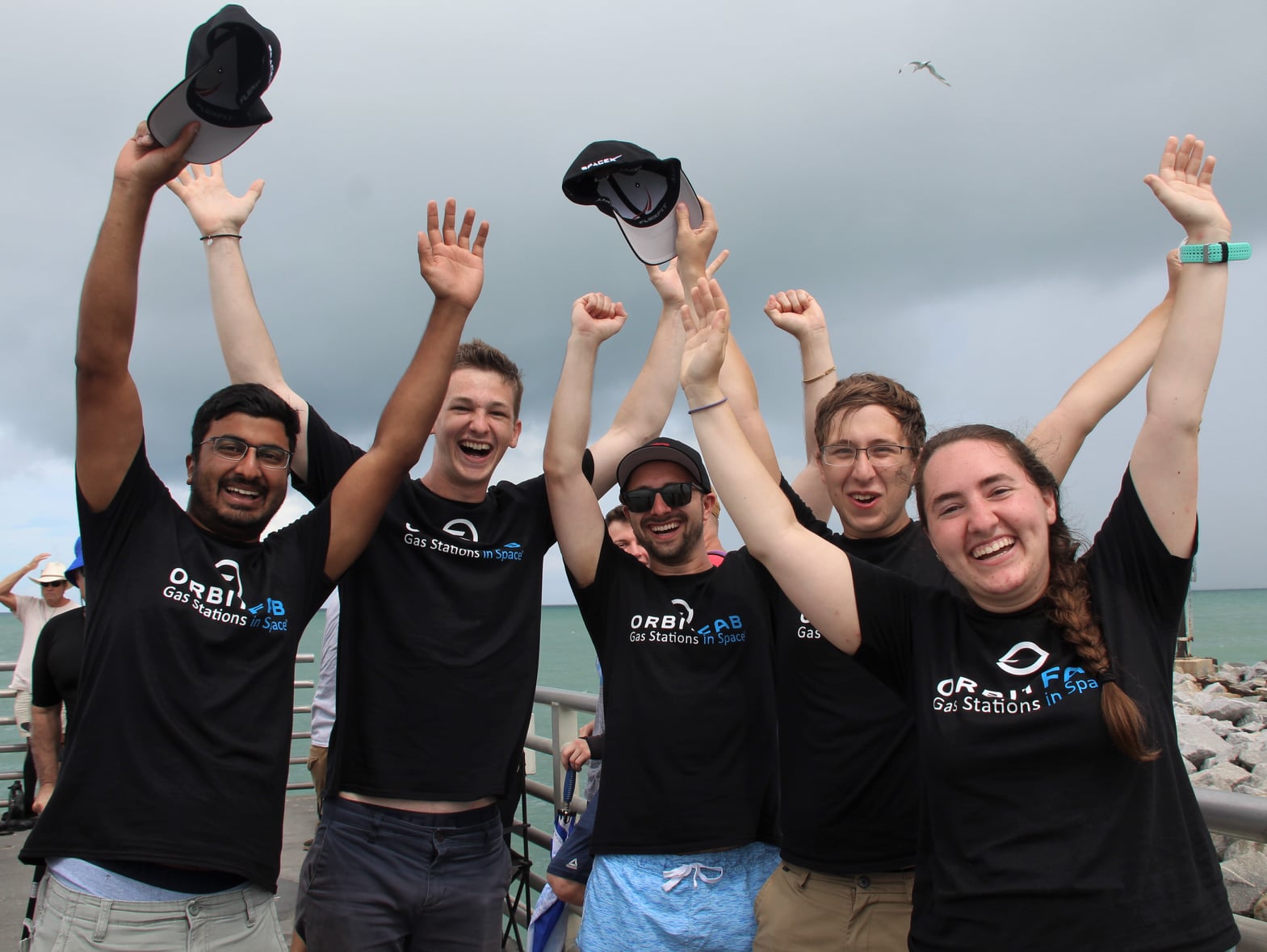 Happy faces of Orbit Fab team members at Tenzing launch with hands raised
