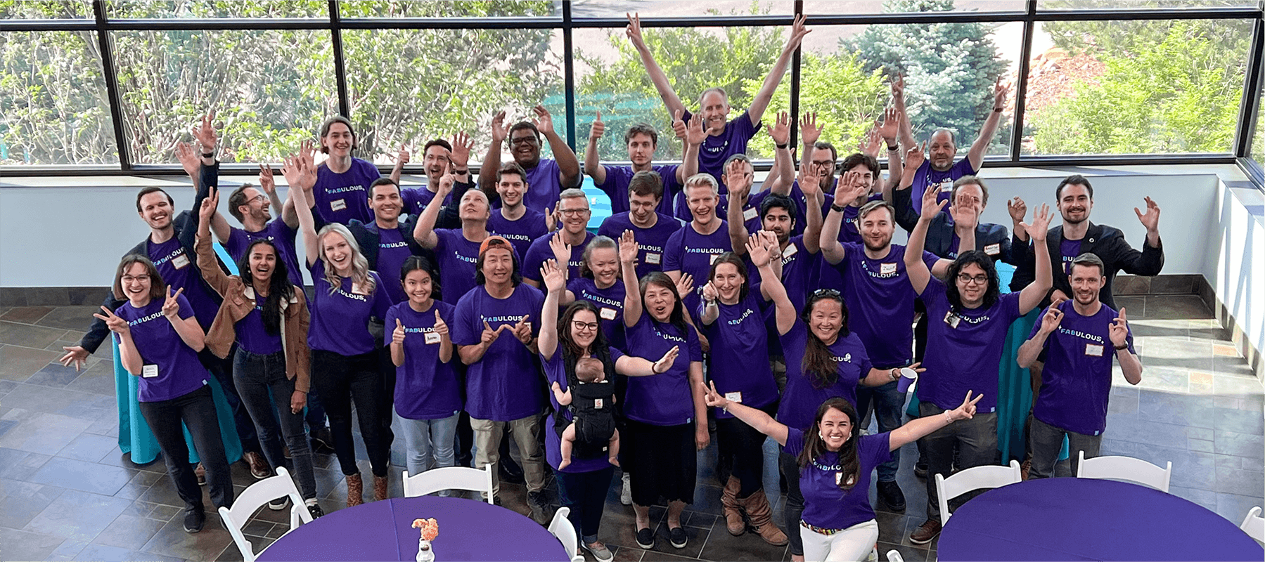 Orbit Fab team with hands outstretched and all wearing purple shirts