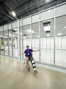 Facilities manager sits smiling in front of the new cleanroom