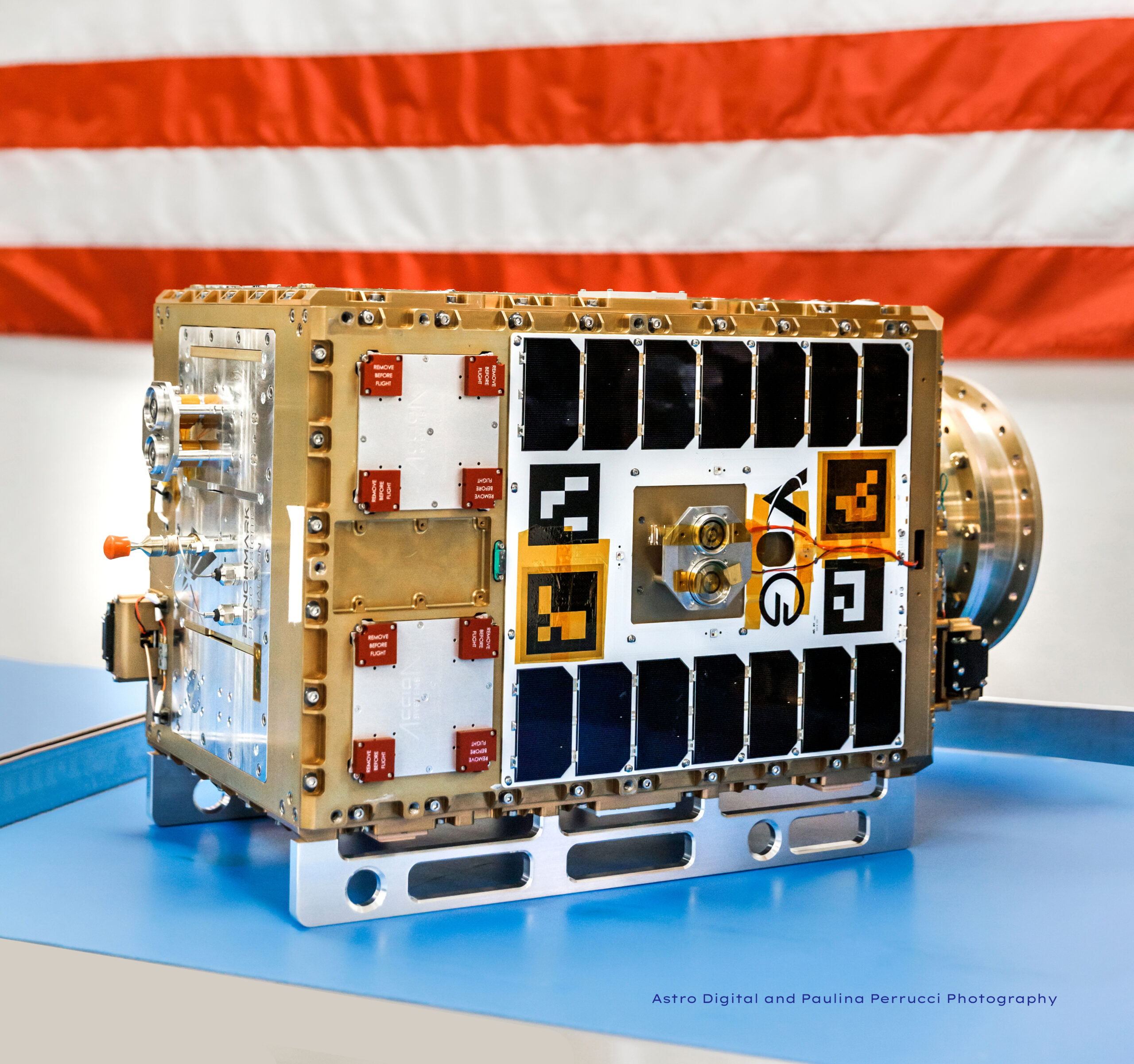 Orbit Fab Tenzing spacecraft on blue surface with American flag in background